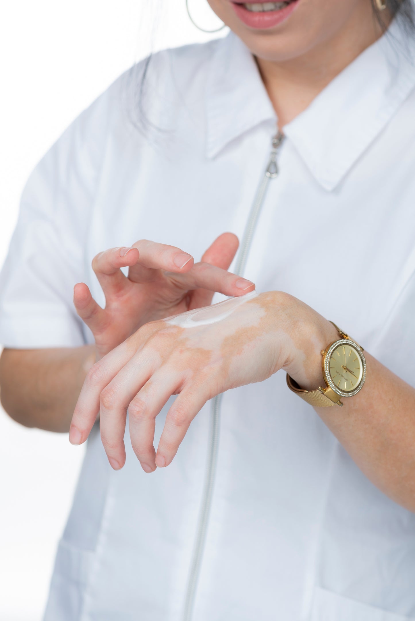 מור מנצור מורחת קרם על גב היד